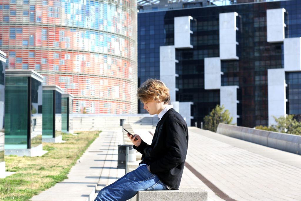 Teenage boy typing text message.Using smart phone