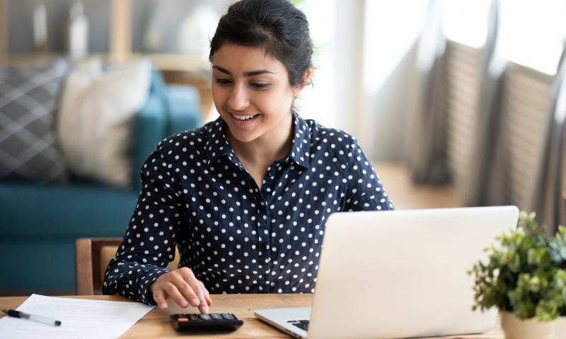 Millennial indian woman paying bills on laptop online